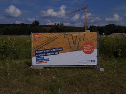 Ein Banner auf einer Wiese zum Neubau der Geschäftsstelle Schwandorf